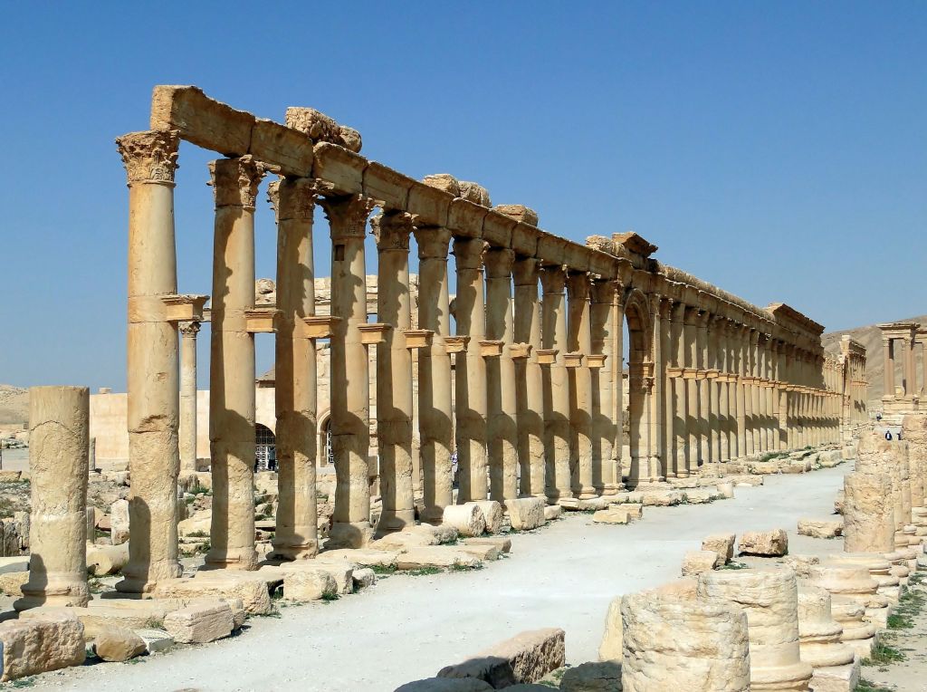Ruins of Palmyra’s colonnaded street and surrounding structures, once part of a caravan city marketplace linking Roman, Persian, Arabian, and Central Asian trade routes.