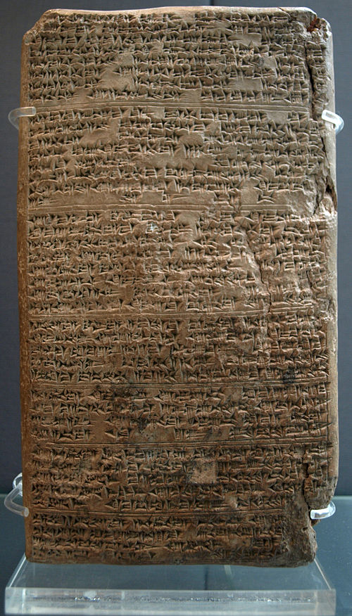 Photograph of a tall clay cuneiform tablet (an Amarna Letter), showing rows of wedge‑shaped writing; this tablet was sent by Tushratta, king of Mitanni, to the Egyptian pharaoh Amenhotep III to negotiate the marriage of his daughter.