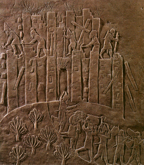 Ancient Assyrian relief showing the siege and destruction of the Elamite city of Hamanu by King Ashurbanipal’s forces, with soldiers attacking the burning city walls.