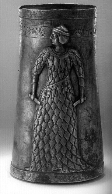 Photograph of an ancient silver cup from Marvdasht, Iran, inscribed with Linear Elamite characters on its surface, displayed in a museum.
