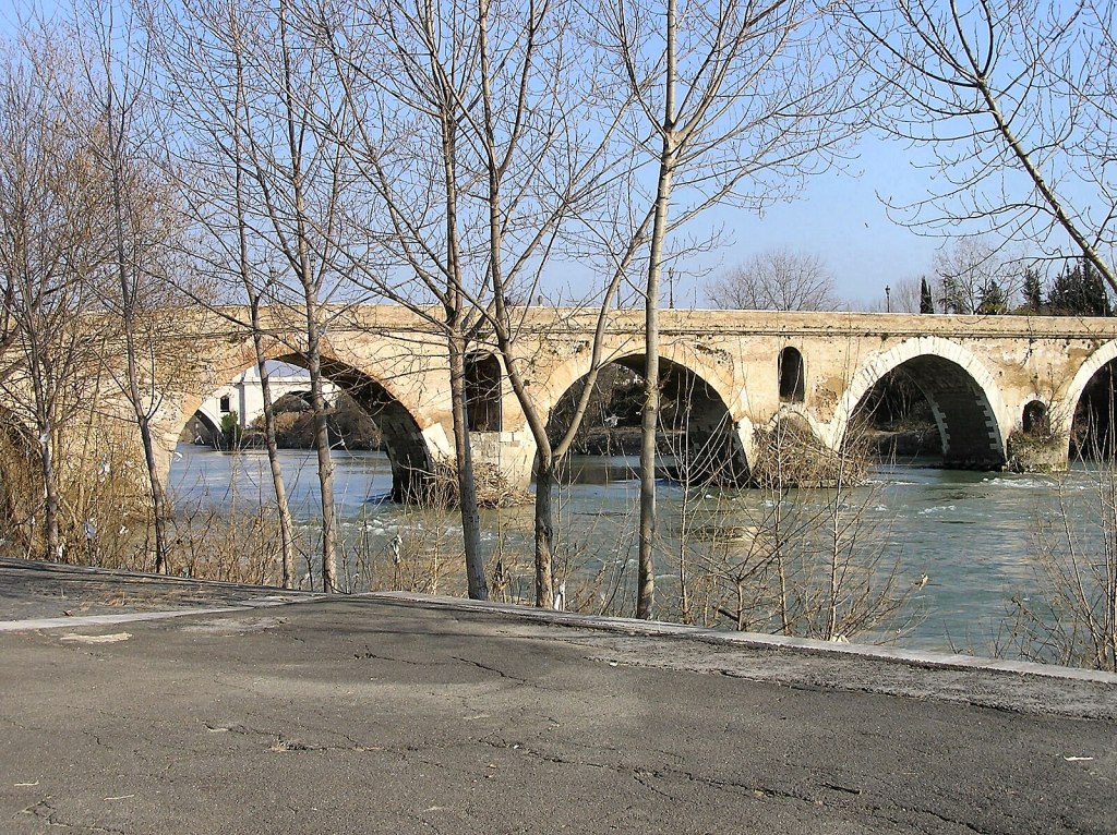 he Milvian Bridge (Ponte Milvio) over the Tiber River in Rome, showing its stone arches and roadway in the present day.