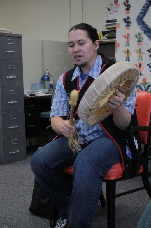 Photograph of Alaska Native storytellers and illustrations depicting a traditional salmon story, showing figures and symbolic imagery used in Indigenous oral narrative traditions.