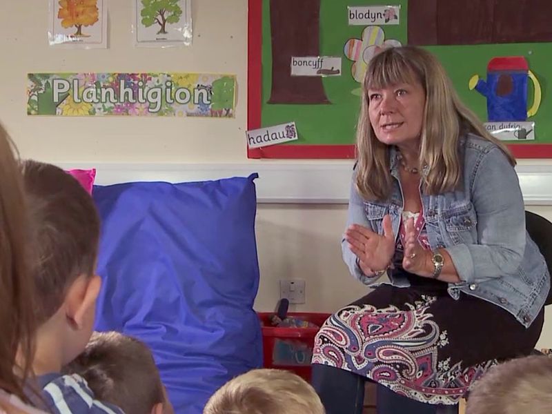 Students in a classroom being taught entirely through the Welsh language, illustrating Welsh as the medium of instruction.