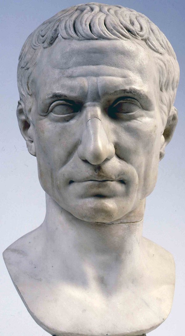 Marble portrait bust of Gaius Julius Caesar showing his distinctive high forehead, receding hairline, and strong features, displayed in the Vatican Museums.