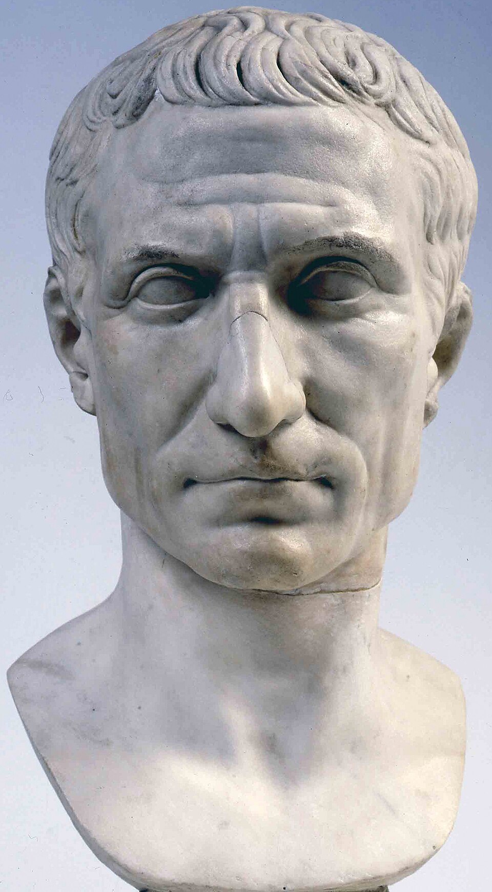 Marble portrait bust of Gaius Julius Caesar showing his distinctive high forehead, receding hairline, and strong features, displayed in the Vatican Museums.